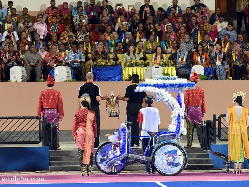 2. the Sultan Azlan Shah Cup is lifted by two hockey Olympians onto the grand stand