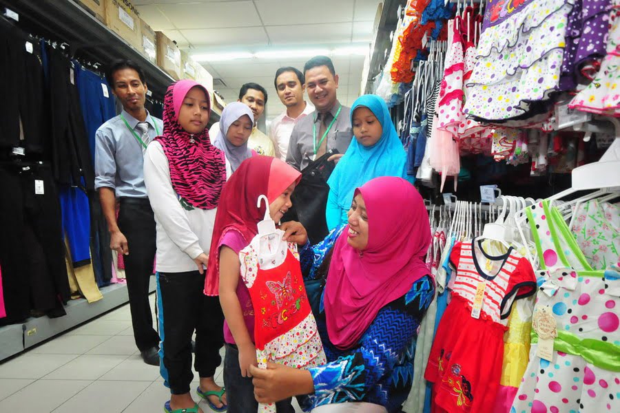 7. the children and their guardian choose new clothes for Hari Raya