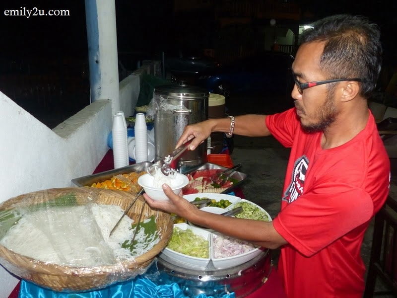 3. a guest helps himself to spicy laksa
