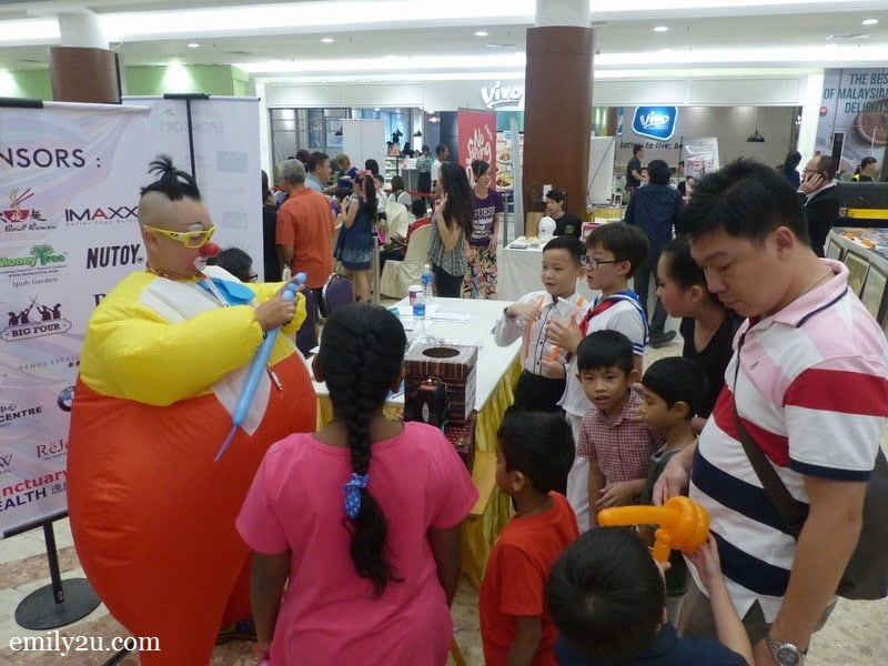 1. Au Young in his sumo suit sculpts balloons for his fans