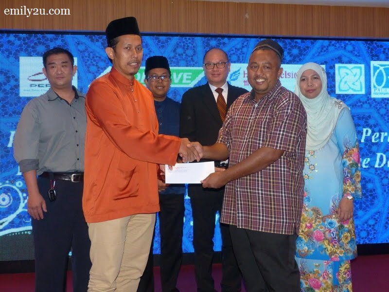5. President of Kelab Sukan & Kebajikan Media Perak Wan Asrudi Wan Hasan (L) presents a cash donation on behalf of the media club to the person-in-charge of Pertubuhan Badan Kebajikan Anak-anak Yatim Darussalam