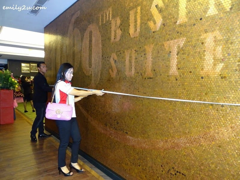  9. official from The Malaysia Book of Records, Ms. Lee Pooi Leng, measures the 1 sen coin mural