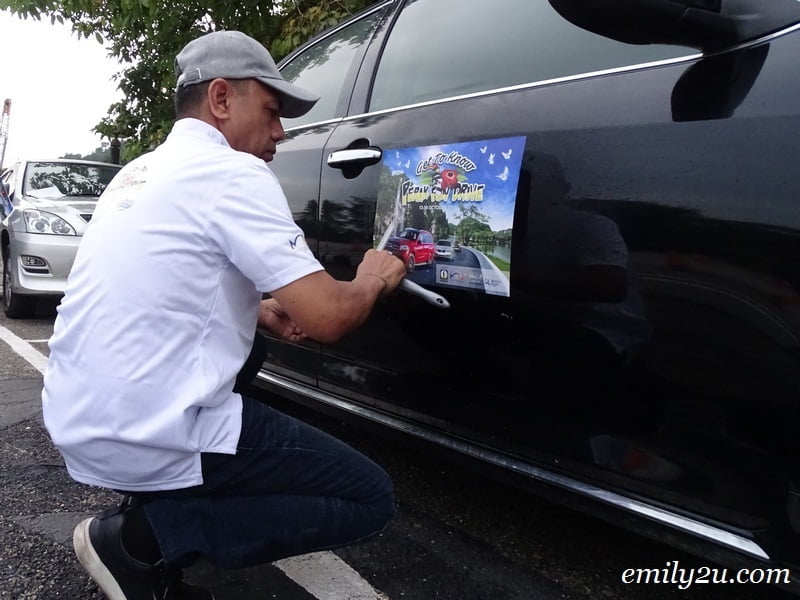  3. Daniel Thexeira pasting Perak Fun Drive stickers onto cars