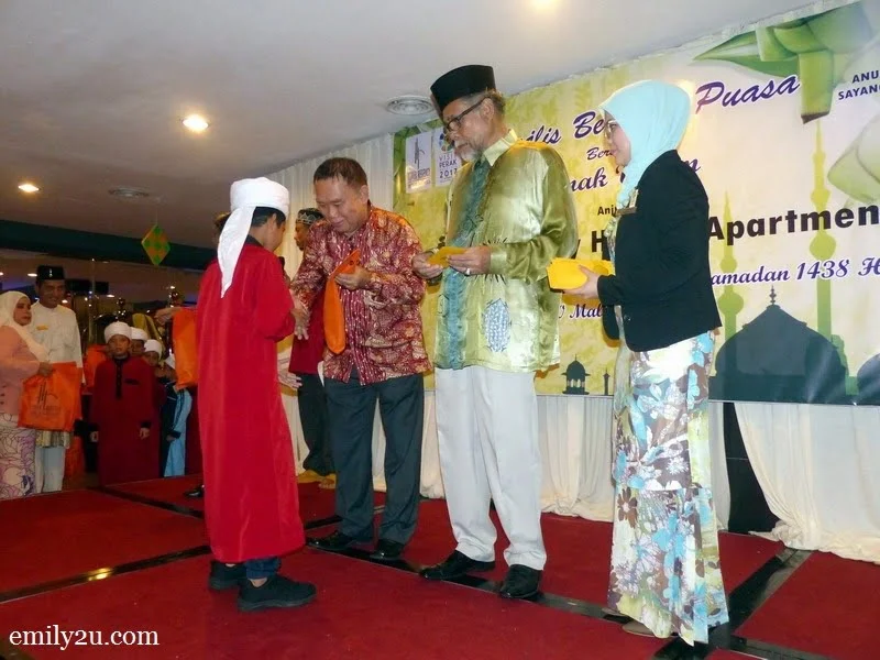 4. hotel director Mr. Simon Leong (L) and sponsor En. Zainal Arif from Empada Sdn. Bhd. (2nd from R) distribute goodie bags and duit raya