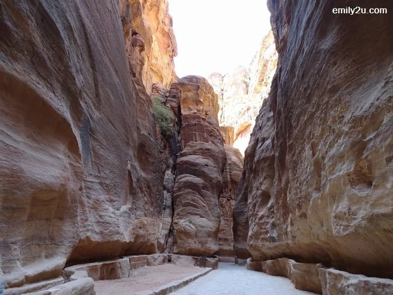 12. a narrow pathway with towering rock walls on both sides