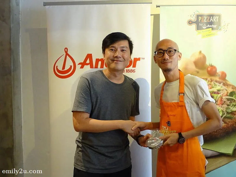 15. Moses of Mustard Sandwich House presenting a prize to pizza eating competition winner, Jan (R)