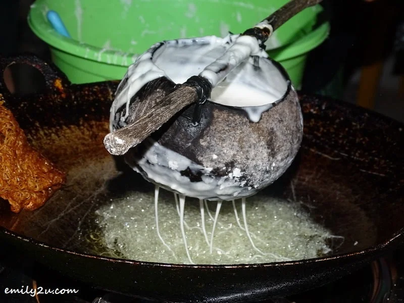 6. swirl the kuih jala mixture into a wok of hot oil