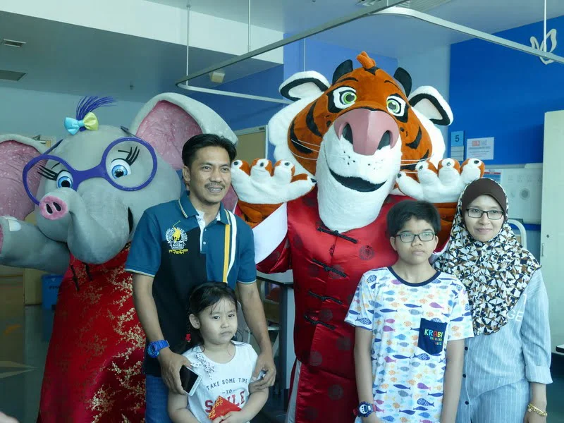 a family takes the chance to pose for a photograph with the mascots
