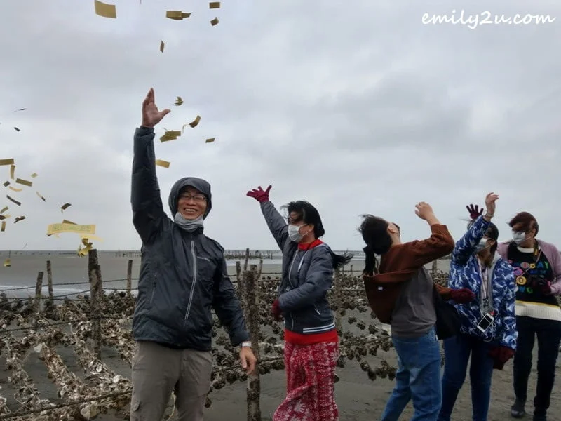 throwing joss paper into the air to appease sea spirits