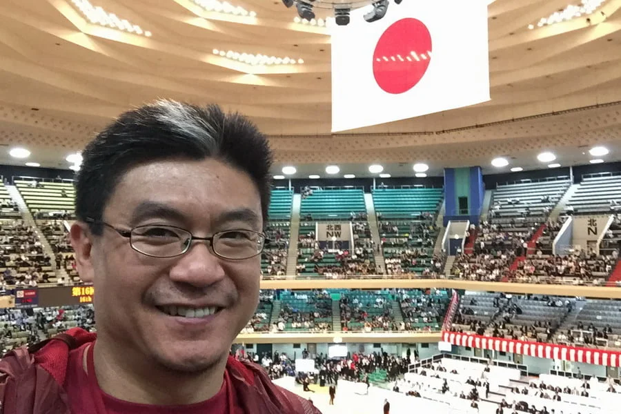 standing in front of the giant Japan flag that is the centrepice in the Nippon Budokan