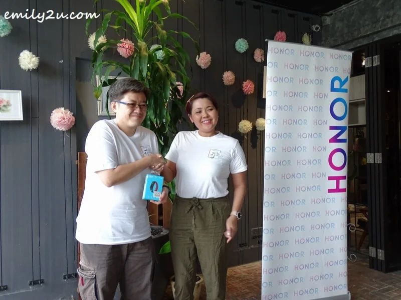 pioneer supporter, Ong Chee Meng (L), wins an Honor wearable device in the lucky draw
