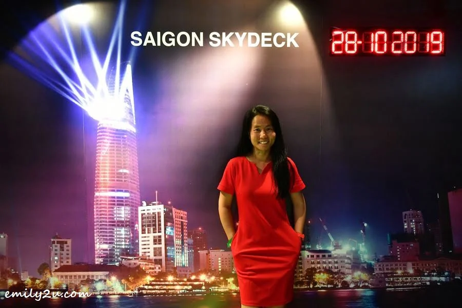 yours truly takes a photo with a mural of Bitexco Financial Tower