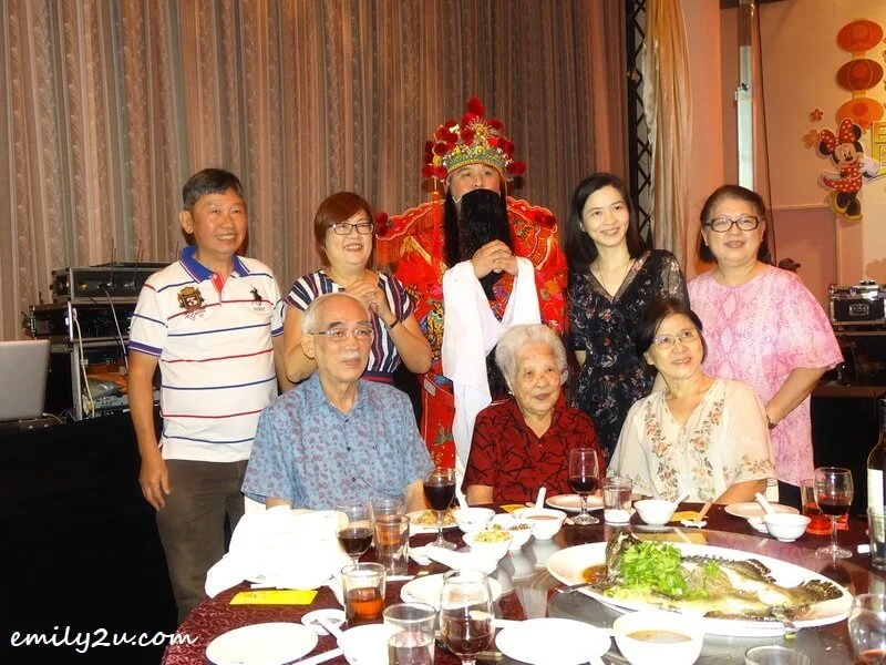  one of the families takes the opportunity to pose with the God of Prosperity