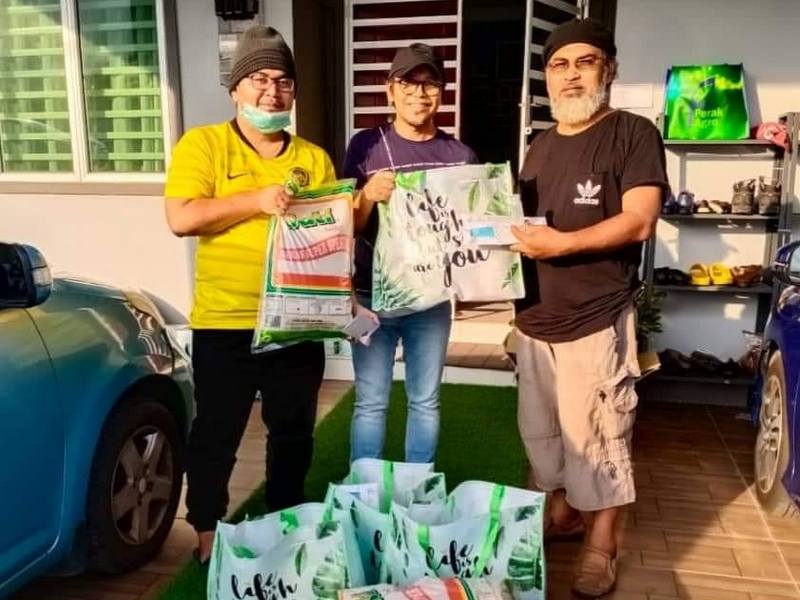 Distribution of care packs. Abang Zul (R) is one of the recipients 