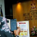 A government officer scans the QR code to use the mobile application SELangkah (Langkah Masuk Dengan Selamat) at Bangunan SUK Shah Alam.