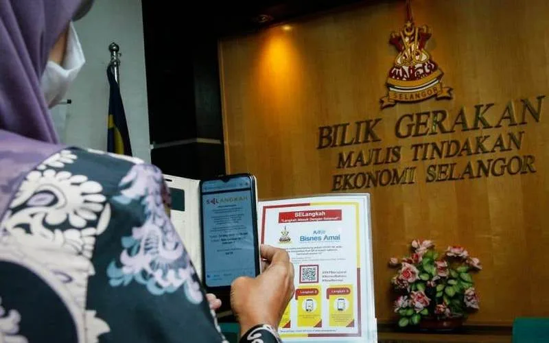 A government officer scans the QR code to use the mobile application SELangkah (Langkah Masuk Dengan Selamat) at Bangunan SUK Shah Alam.