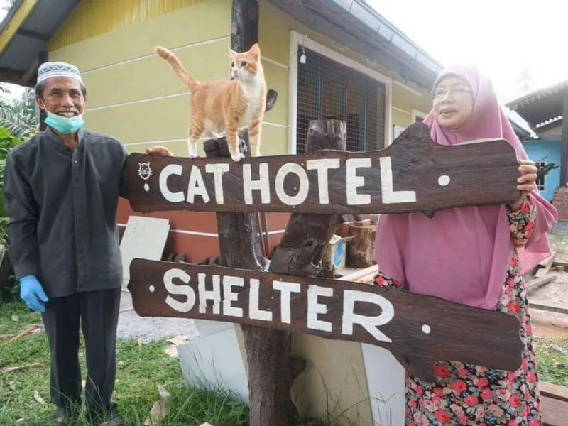 Dr. Taq's parents pose in front of Cat Hotel