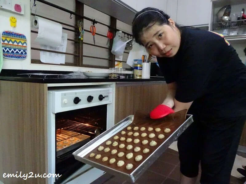 Keen places a tray of cookies in the oven