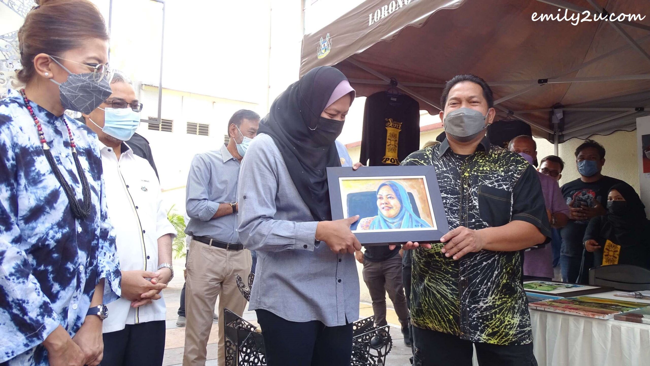State Tourism Committee Chairperson YB Yang Berhormat Dato’ Nolee Ashilin Binti Mohammed Radzi receives a painting of herself from UiTM Seri Iskandar