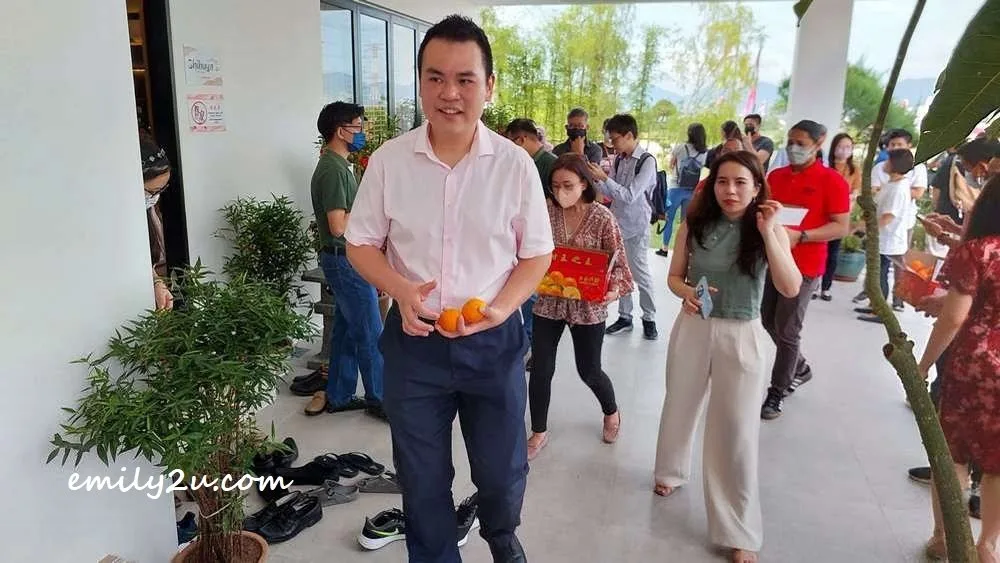 YB Chong offering a pair of mandarin oranges to every visitor