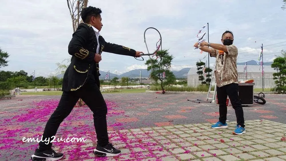 Peter Au Young (L) entertains visitors with his dangerous whip act