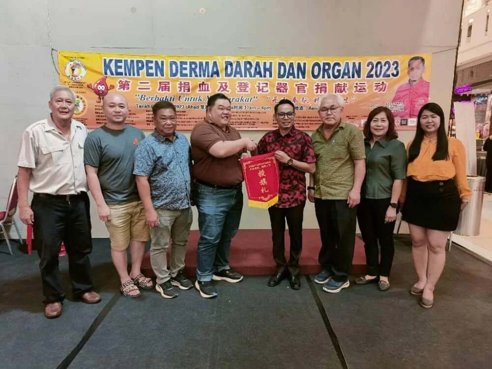 Mr Jeremy Lee (in brown shirt) receives the stewardship for the third edition of the blood donation drive and organ pledge campaign