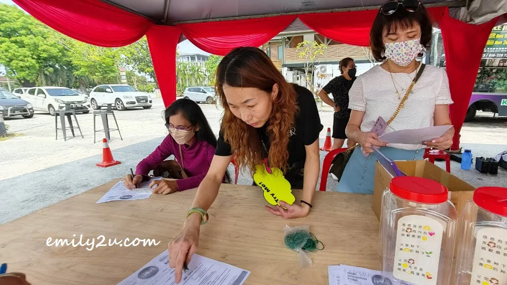 one of the crew members guiding donors in filling out the hair donation form