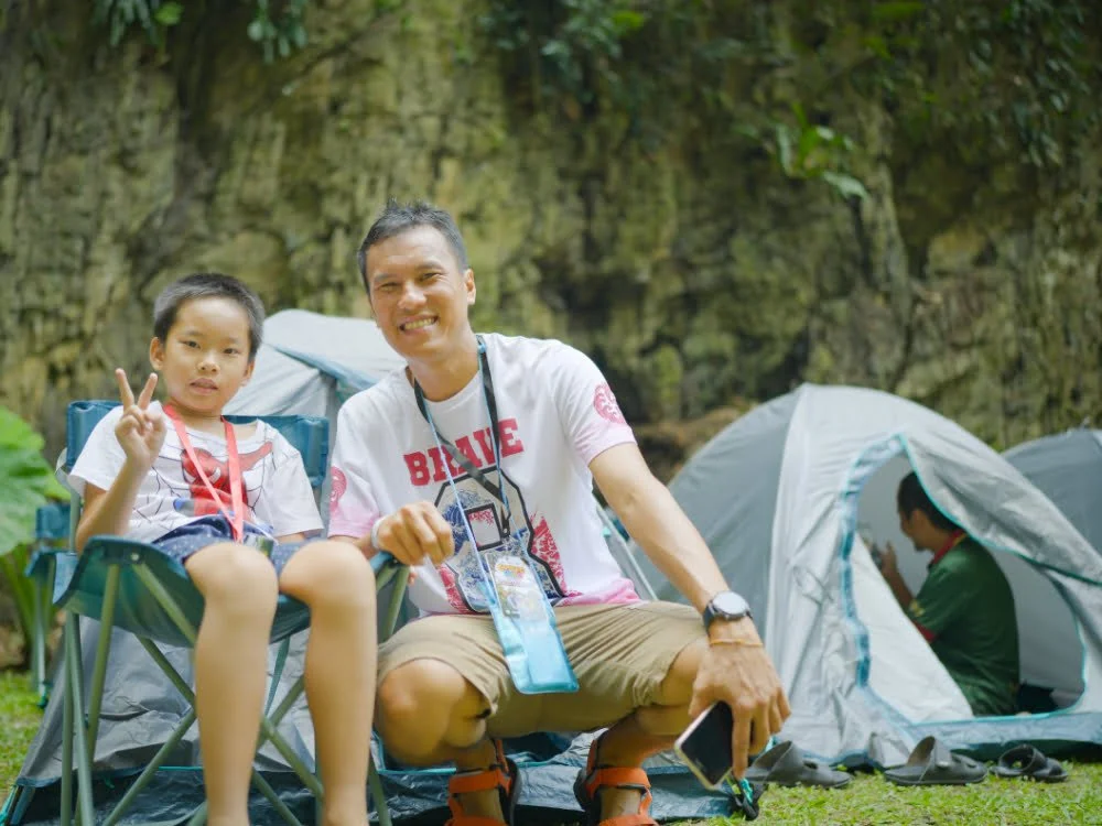 a father and child chilling at the camp ground
