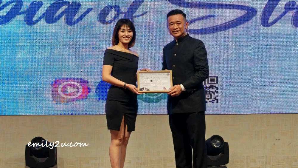 Ms Clair Chong (L) of Shake & Bake Artisan Bakery receives her certificate of appreciation for sponsors