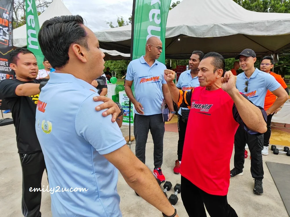 10-time Mr. Universe Sazali Abdul Samad (in red) explains the purpose of different weights