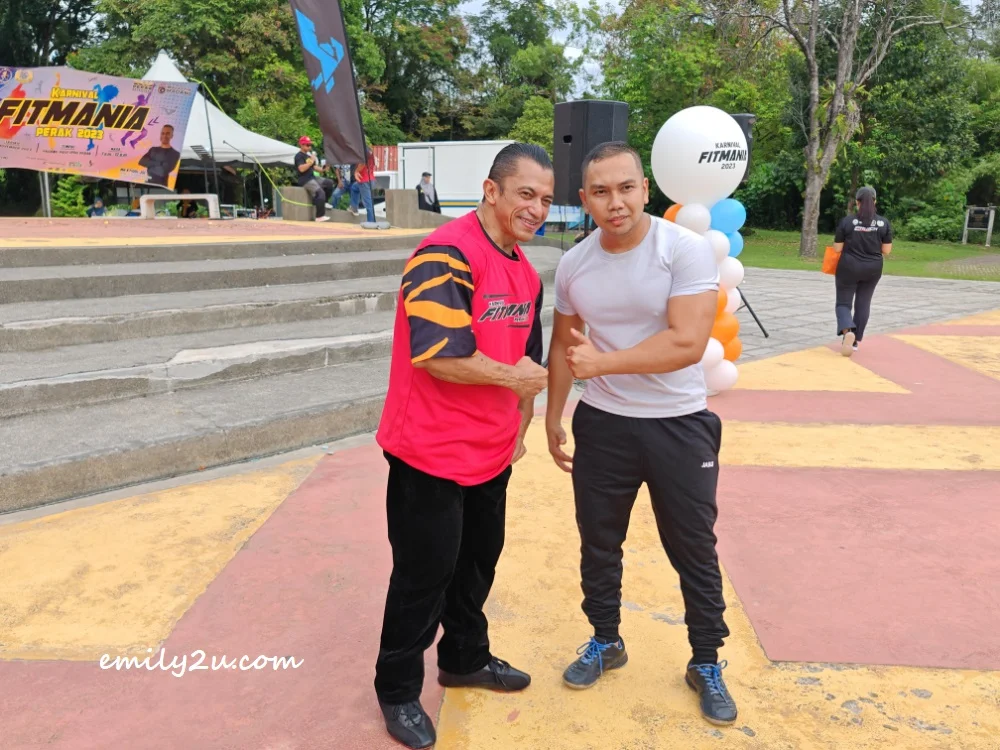 a fan poses with 10-time Mr. Universe Sazali Abdul Samad (L)