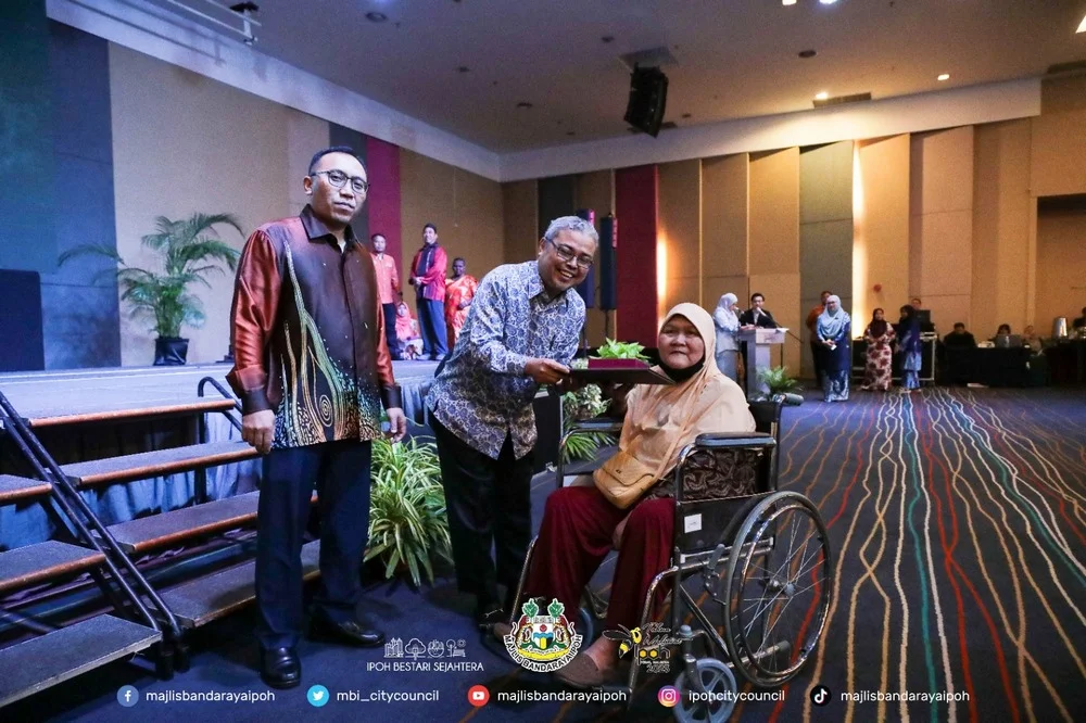 Ipoh City Mayor Y.Bhg. Dato' Rumaizi bin Baharin@Md Daud (M) presents a certificate of appreciation and souvenir to a MBI retiree (R)