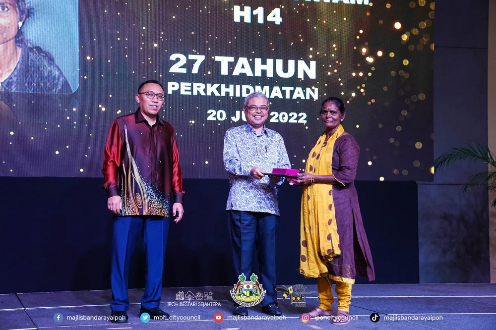 Ipoh City Mayor Y.Bhg. Dato' Rumaizi bin Baharin@Md Daud (M) presents a certificate of appreciation and souvenir to a MBI retiree (R)