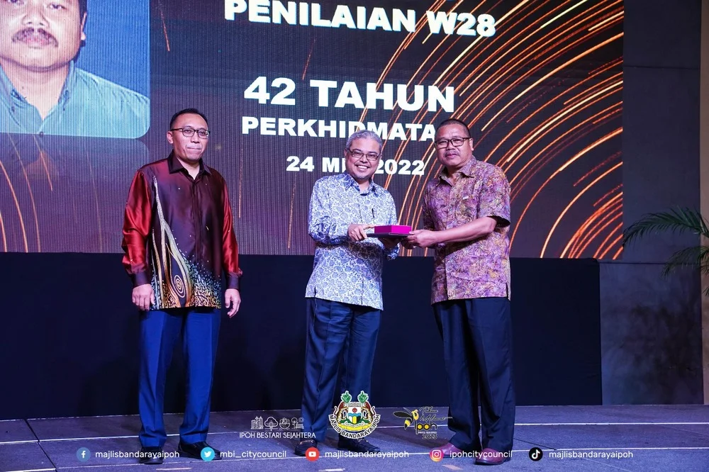 Ipoh City Mayor Y.Bhg. Dato' Rumaizi bin Baharin@Md Daud (M) presents a certificate of appreciation and souvenir to a MBI retiree (R)