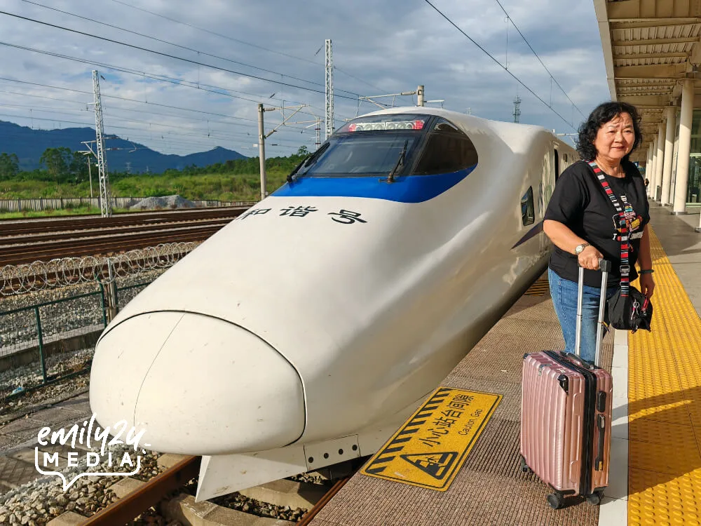Mrs Chin poses with the high-speed train upon arrival at Guilinxi Railway Station (West Guilin Railway Station)