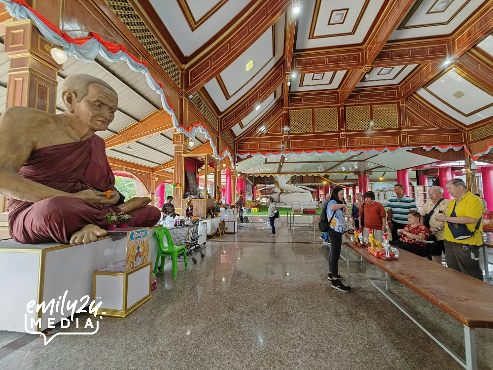 devotees offer gifts to Luang Phor Thuad (L)