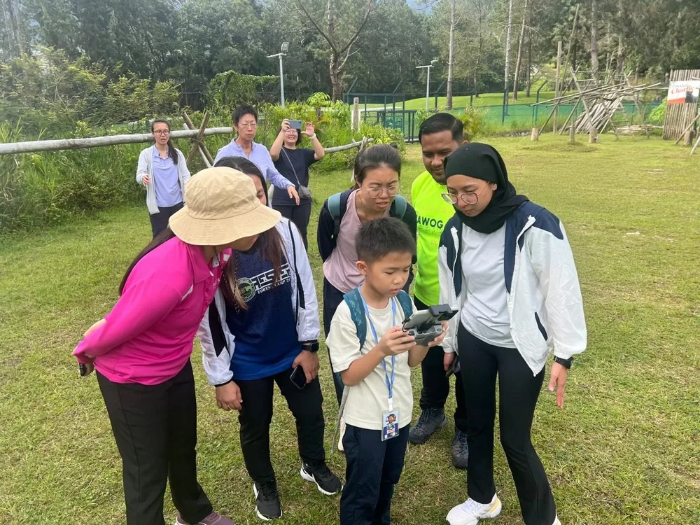 Dao Her shows the GNA team how to fly the drone