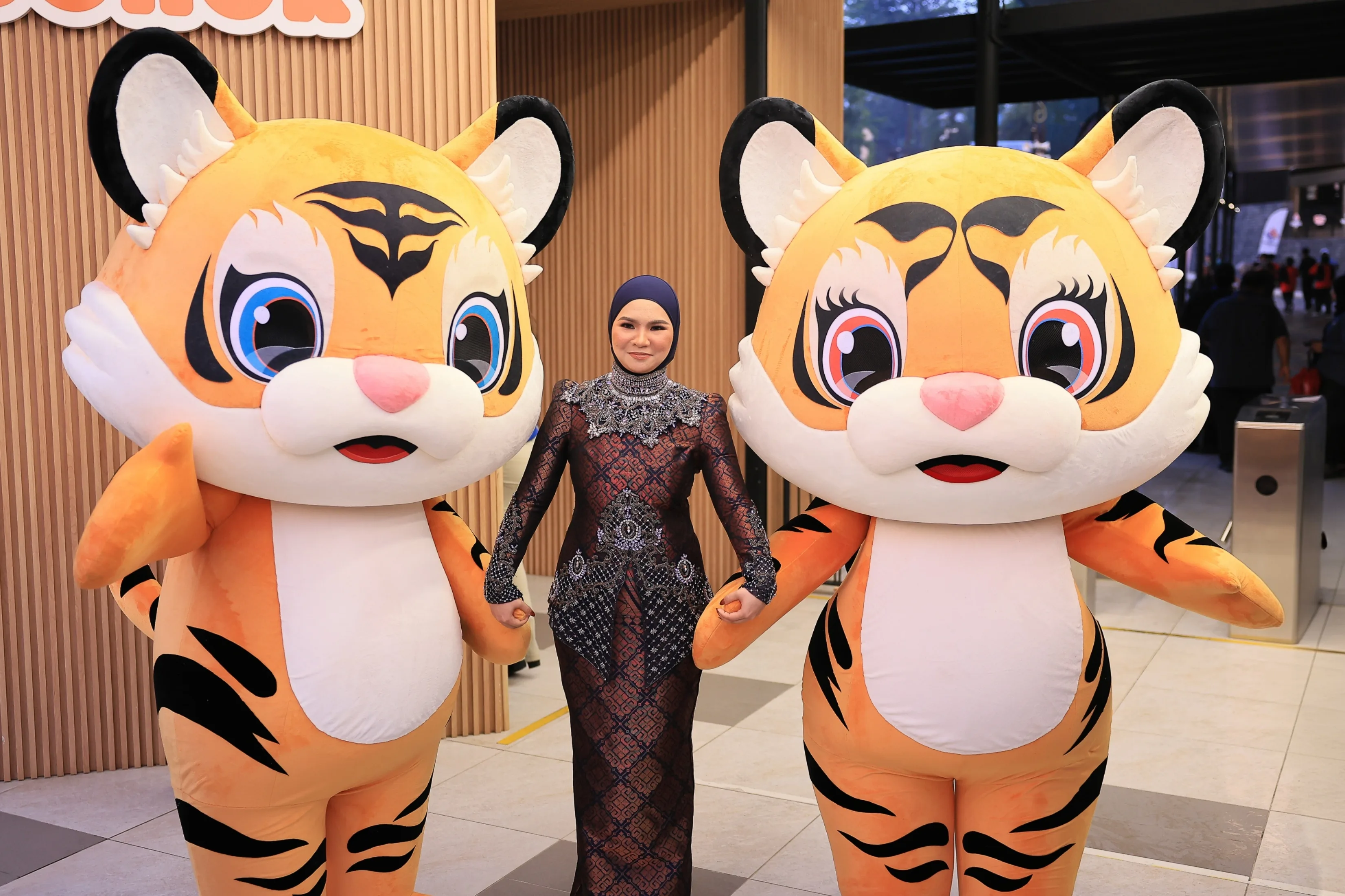 Aina Abdul poses with Cuping and Jucy during the launch event of the official mascots, tagline, song and video for Visit Johor Year 2026